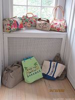 Seven assorted travel bags and purses displayed together on a white radiator cover and floor.