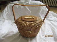 Front view of the woven Nantucket style basket purse with wooden handle on white fabric background.