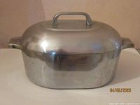 Front view of roasterette with lid showing handle and side handles, metal body reflects light, dated 04/05/2025