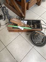 Two outdoor electric water fountains laid on a floor with metal pump parts and wooden bases, showing overall condition and components