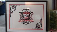 Full view of framed and matted Indigenous art print showing red, black and white Northwest Coast design