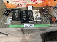 Metal bookmarks and keychains with owl motifs and a leather coin purse, arranged on countertop