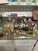 Full view of owl figurines and collectibles spread out on a counter showing various styles and sizes.