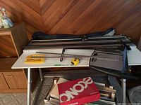 Overall view on drafting table showing mat cutter, rulers, tape runner, paper trimmer and supply box