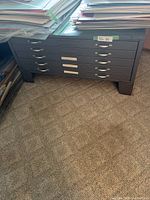 Front view of black 5-drawer flat-file cabinet with stacks of mat boards on top