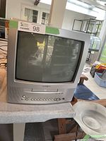 Front view of the Toshiba TV/DVD combo showing the CRT screen, Toshiba logo, DVD tray, control buttons and input ports.