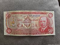 Front side of the 1975 Canadian $50 banknote showing the portrait of William Lyon Mackenzie King, red color scheme and value markers.