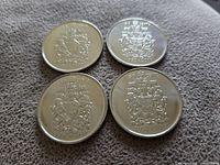 Four Canadian 50-cent coins with Royal Coat of Arms on reverse side marked 1952-2002 Golden Jubilee