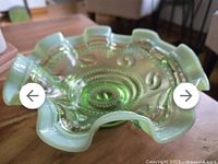 Top angled view showing the ruffled edge, comet rings, and beaded pattern in translucent green opalescent glass with a milky crimped rim.