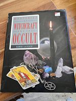 Front cover of the Mysteries of Witchcraft and The Occult book showing title, author, and occult-related imagery including crystals, tarot card, pentagram pendant, and lit candle.