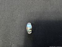 Front view of the round bead showing multifaceted, multicolored glass surface.