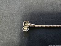 Close-up of the clasp mechanism showing the fold-over style of the silver bracelet.