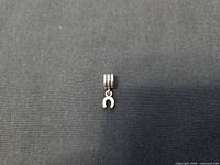 Front view of sterling silver horseshoe charm on double-ring bail showing smooth polished side.