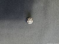 Top view of Pandora sterling silver snowflake charm showing gemstone accented snowflake design