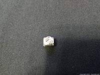 Charm top and front view showing detailed travel motifs including luggage tag and heart symbol on the suitcase charm.