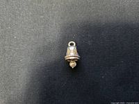 Sterling silver wedding bell charm with detailed edge and a small bead dangling inside the bell