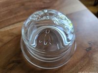 Top view showing the embossed bee design on the lid of the glass honey jar