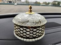 Side angle view of vintage potpourri dish showing metal mesh body, glass base, and decorative glass lid with finial knob.