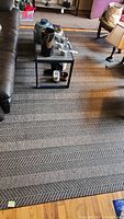 Gray and black patterned Crate & Barrel area rug runner under living room table