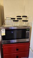 Front view of Panasonic stainless steel microwave with glass jars on top