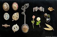 Full layout of thirteen vintage jewellery pieces on black background