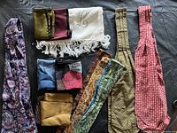 All items laid out showing variety of ascots, pocket squares and scarves