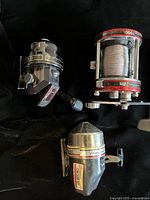 Group shot of three fishing reels on black background
