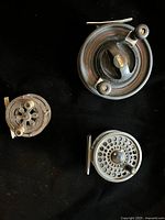 Group shot of all three fly reels on black background