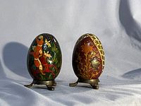 Front view of both lacquered eggs on stands