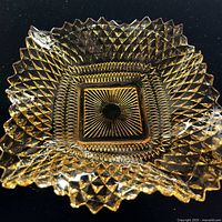 Top view showing amber square dish with ruffled sawtooth rim and starburst pattern