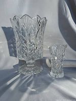 Two crystal vases side by side on fabric backdrop