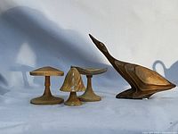 Overall lot showing three wood toadstools and one carved bird