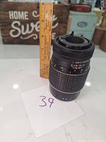 Photo showing the overall height and details of the vintage camera lens with manual aperture and focus markings.