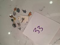 Photo of 14 assorted charms for bracelet, various animal and object shapes in silver and enamel