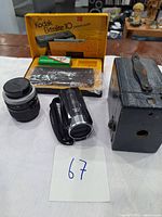 Full lot view showing Kodak Ektraite 10 box camera, Canon lens, Kodak film pack, Canon digital camcorder, and original Kodak box.