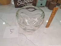 Front view of a clear glass bowl with ruler for scale, showing about 4 inches height
