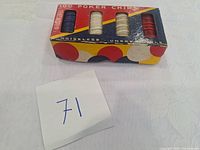 Original colorful box with compartments for blue, white, and red poker chips. Box shows wear consistent with age and use.