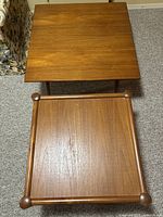 Top view of both teak end tables arranged side-by-side showing surface and wood grain.