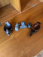 Overview of all five carved stone animal figures and the raven ashtray.