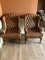 Two wingback chairs side by side showing overall appearance.