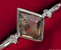 Front view showing square bezel set diamond flanked by accent diamonds