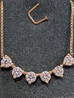 Necklace front view on black background with gold chain and six round diamonds