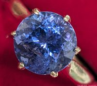 Top-down view of round tanzanite center stone in six-prong setting
