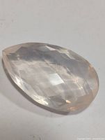 Faceted pear-shaped rose quartz gemstone showing translucent soft pink hues.