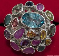 Front view showing the cluster of multi-colored gemstones with a large central blue stone.