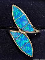 Close-up image of a sterling silver ring with two marquise-shaped inlays of blue-green opalite segmented into three parts each