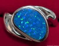 Close-up of the silver ring showing the blue opalite stone with blue and green iridescence.
