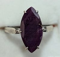 Close-up image of the marquise-cut ruby gemstone set in silver ring, showing shape, color and prong setting.