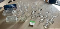 Assorted crystal glassware including wine glasses and cut crystal trays arrayed on table