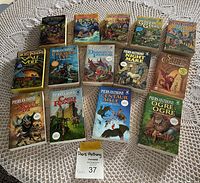 Photo of 14 Piers Anthony paperback novels fanned out and spread on lace tablecloth.